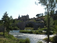 Puente medieval románico de Auzola o Bidelepu sobre el río Irati. Al fondo San Miguel